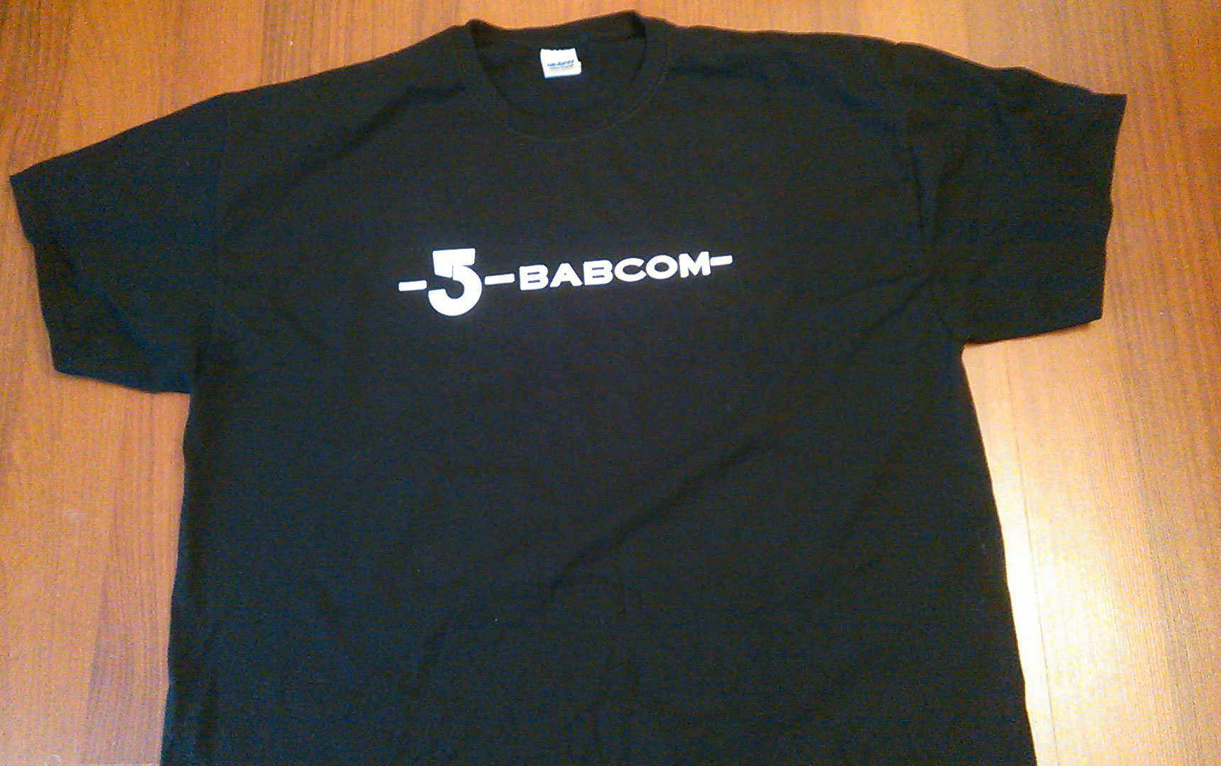 White BABCOM logo on black t-shirt