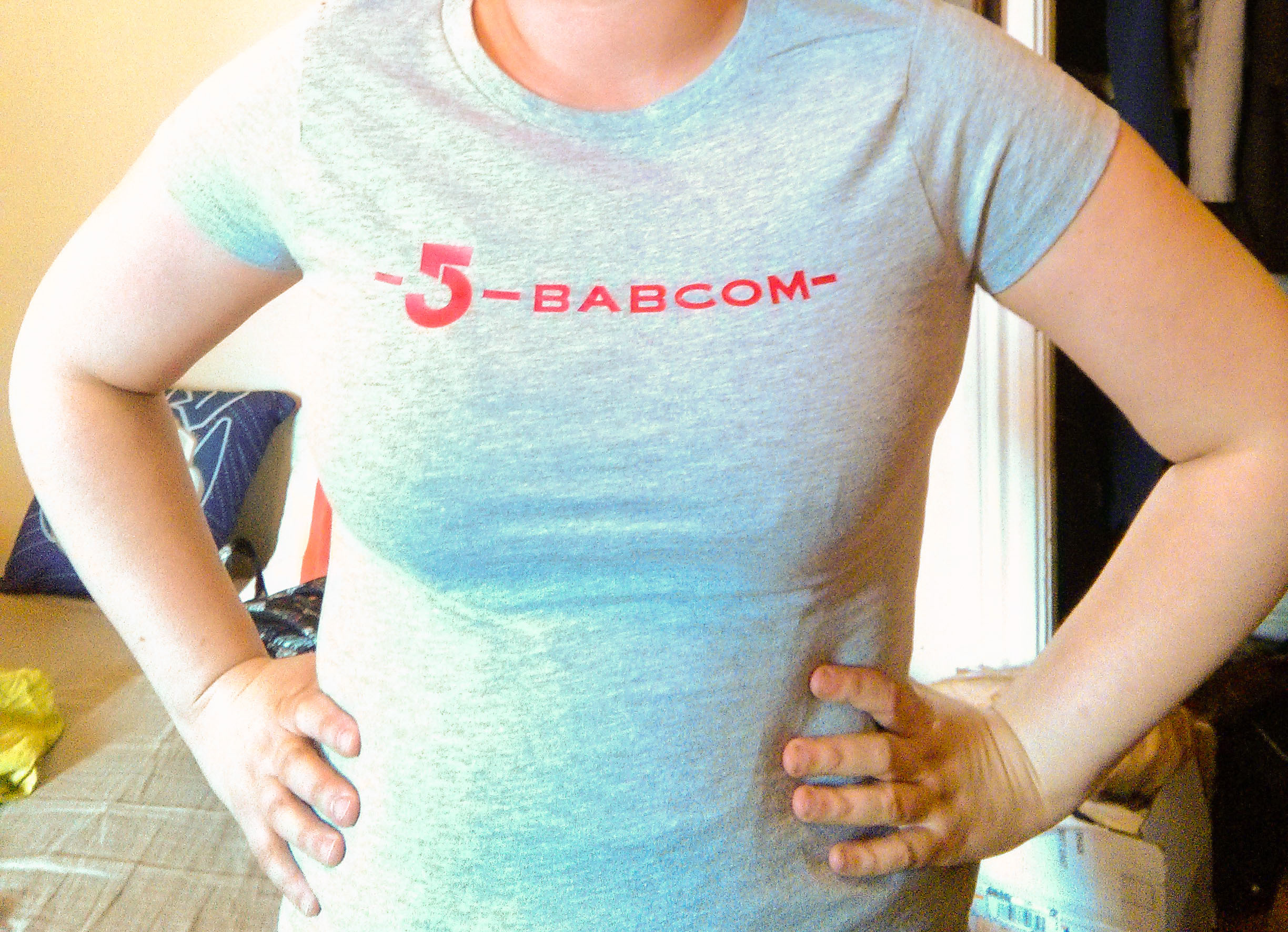 Red BABCOM logo on grey t-shirt